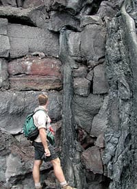 Greg Kurras, a student at U. Hawaii, SOEST, standing at the beach cliff at the shoreline where the Pu’u Oo eruption was entering the sea in June, 2001. Note the layers of lava, each about 1 meter thick. Note also the narrow flow that has cascaded down from a small tube in one of the flows at the top of the photograph. The next photo shows a close up of this small lava tube. Scale from top to bottom of image is about 5 meters.