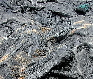 Pahoehoe lava transitioning into ropy pahoehoe (at left of photograph) on Kilauea volcano, Hawaii. Daypack at upper right for scale.