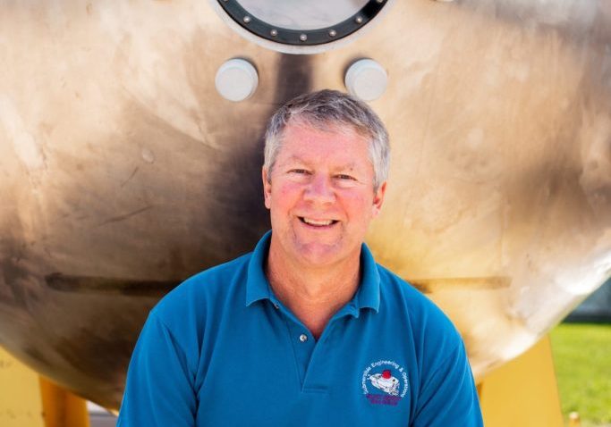 Rick Chandler poses with an older-model ALVIN personnel sphere. (Photo by Daniel Hentz © Woods Hole Oceanographic Institution)